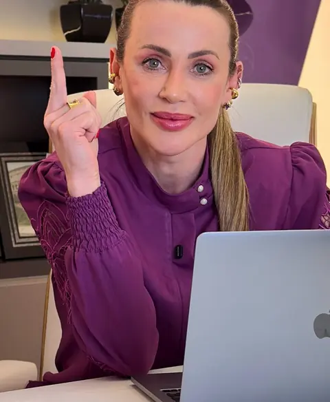 Dra. Sulingue explicando, sentada à mesa do consultório