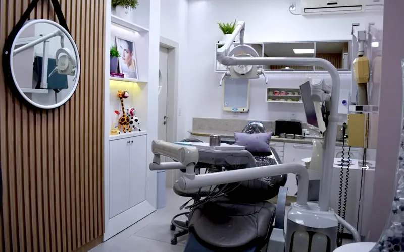 Sala de atendimento com cadeira odontológica e espelho redondo